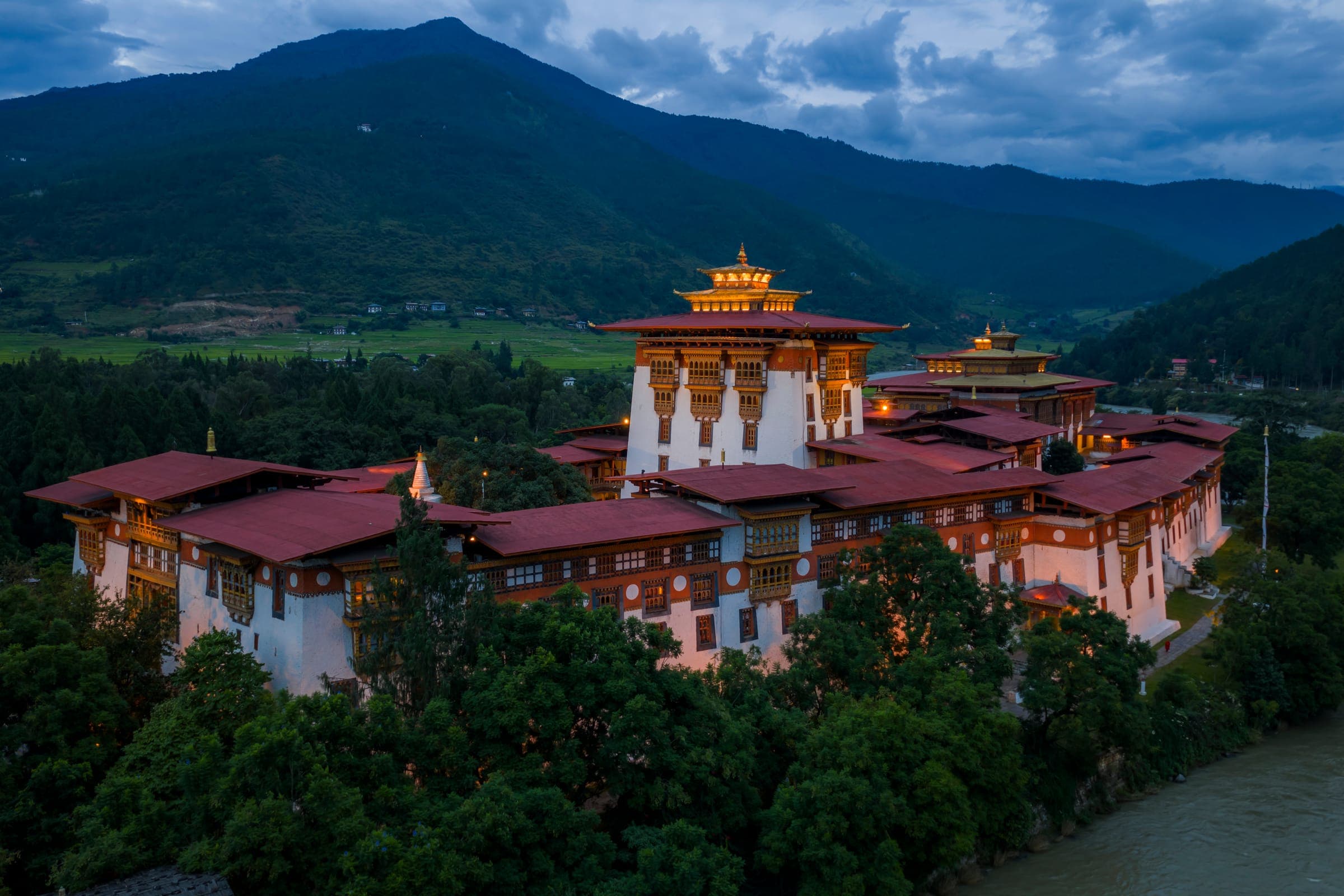 Aerial view of Punakha Dzong beside the river with red-roofed courtyards